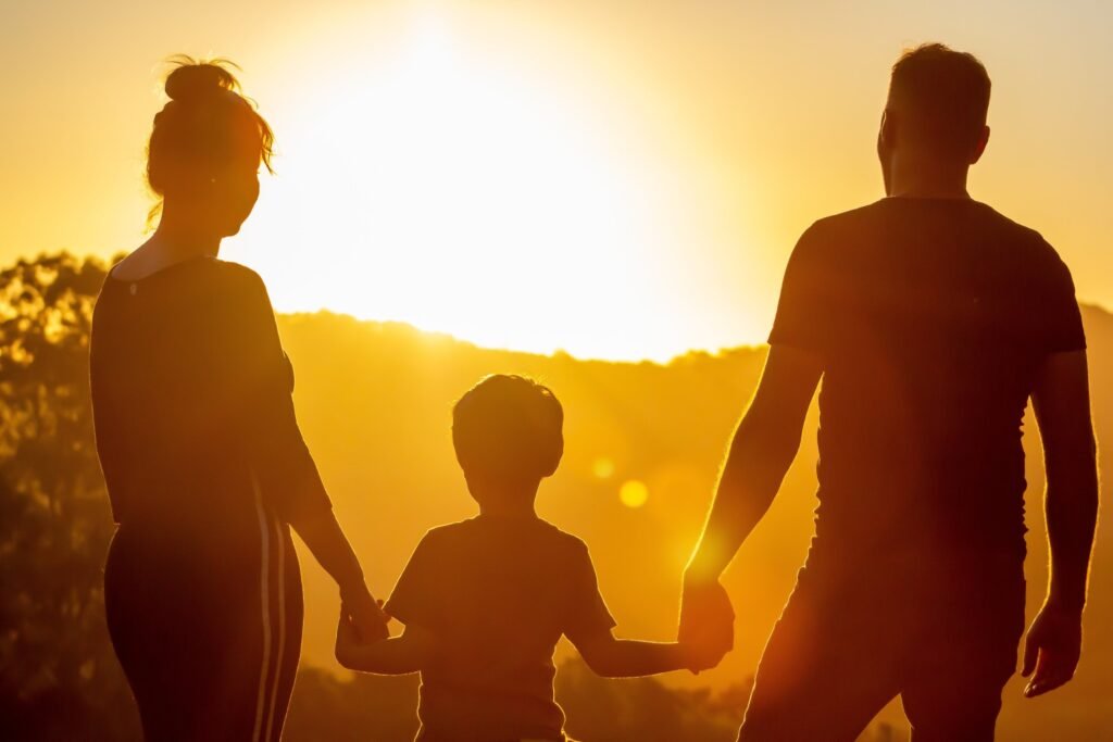 A family walking hand in hand at sunset