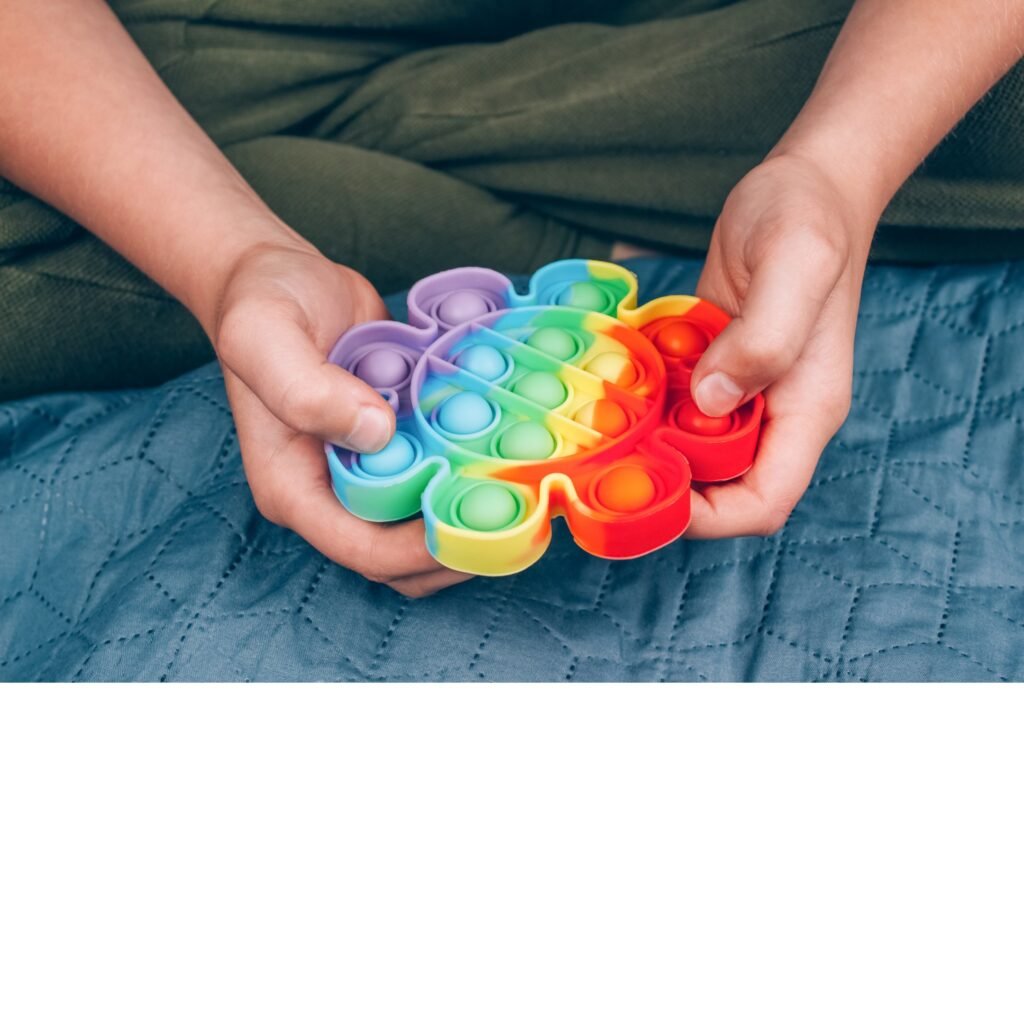 Hands pressing a rainbow fidget toy