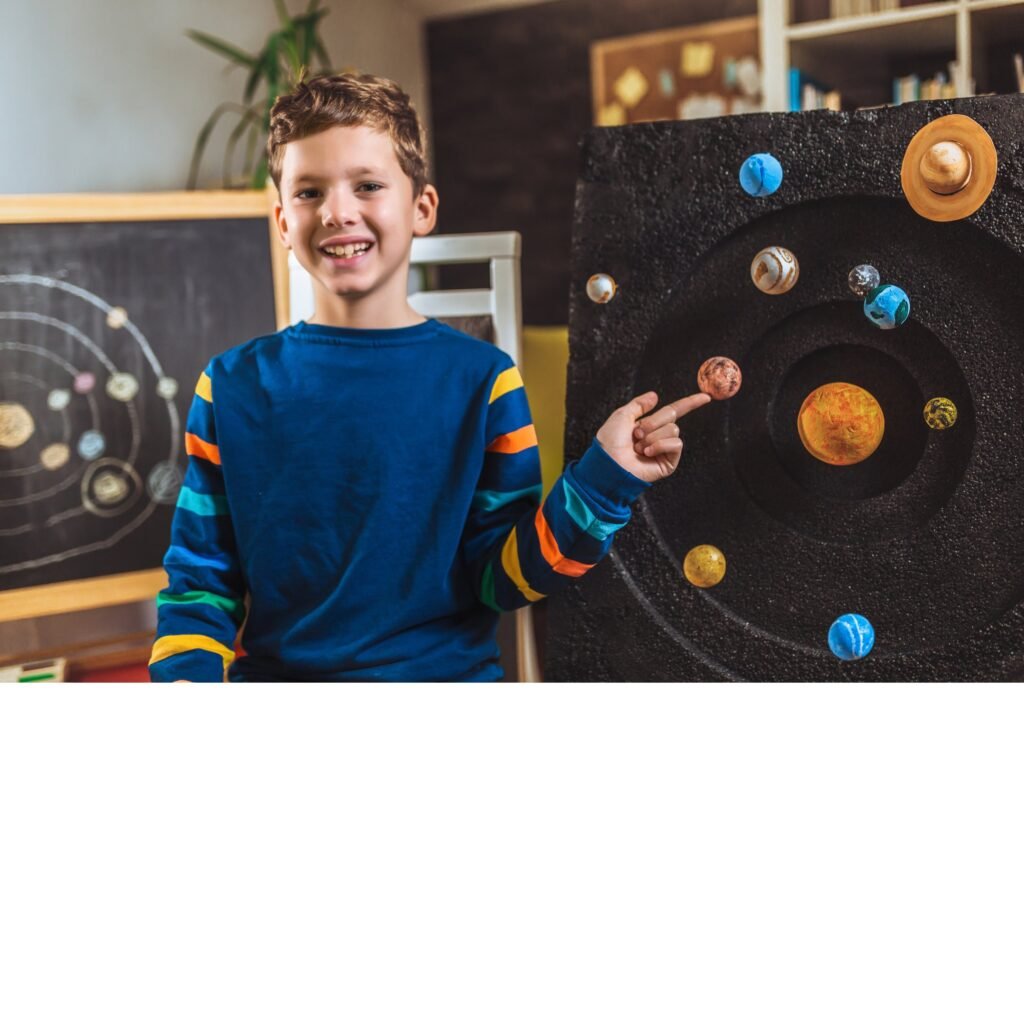 A boy pointing at a model of the solar system
