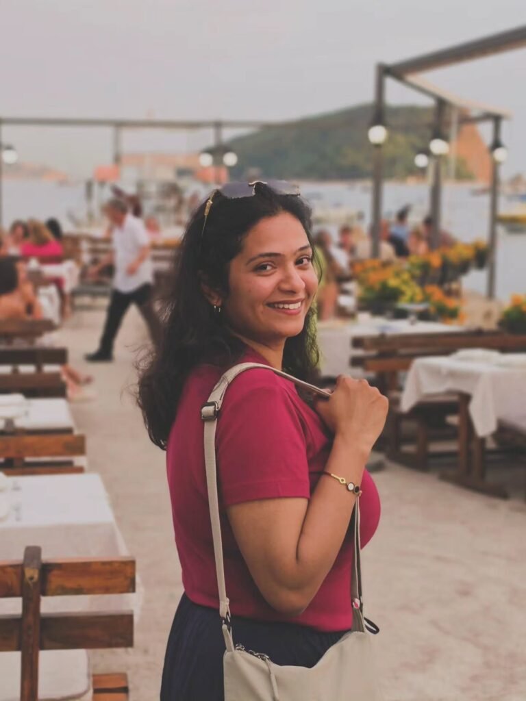 Apurva smiling at an outdoor café in Montenegro